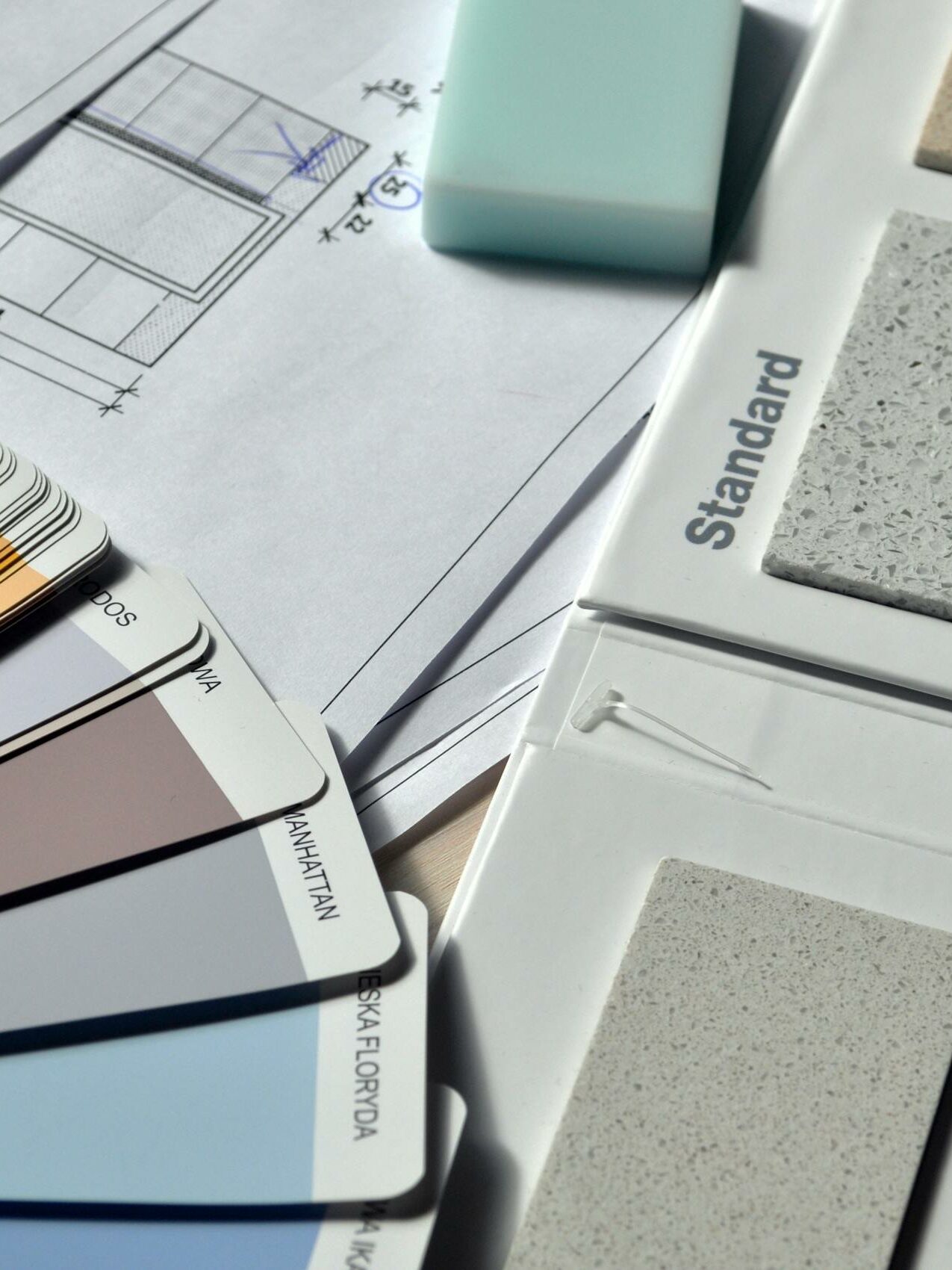 Color palette and material samples for interior renovation projects on a blueprint.